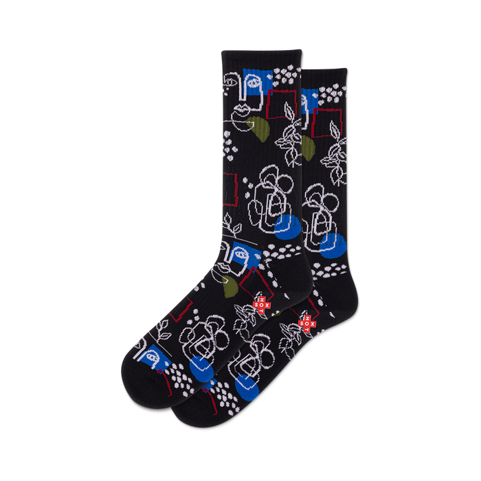 Pair of black crew socks with a whimsical design featuring abstract faces, floral elements, geometric shapes, and pops of blue and green.