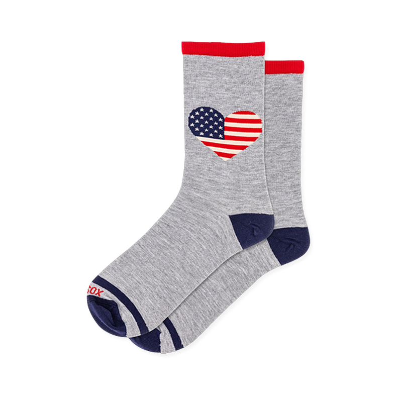Grey crew socks featuring a heart shaped American flag pattern with stars and stripes, red cuffs, and solid navy toes.