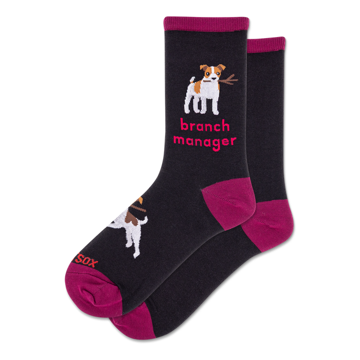 Pair of black crew socks with magenta cuffs, heels, and toes. Design features a white dog holding a stick and