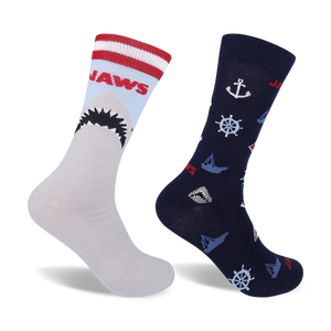Two crew socks. One gray with red/white stripes and a Jaws shark graphic; one navy blue with nautical anchors, wheels, and small shark graphics.
