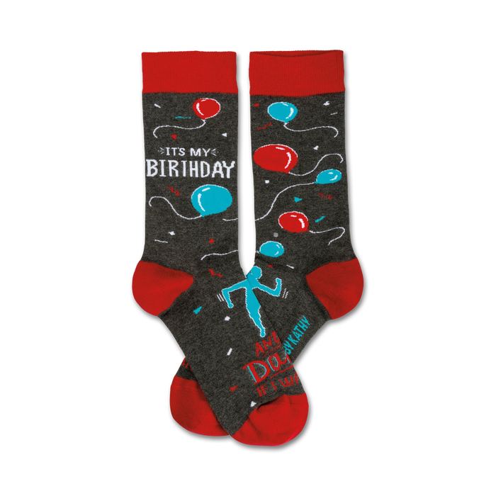 A pair of crew socks in grey with red cuffs. The socks feature teal and red balloons, a dancing figure, and the text 'It's My Birthday'. }}