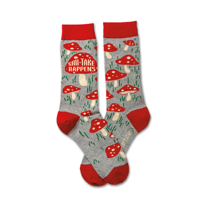 A pair of crew socks in grey with red mushroom designs and the text 'Shii-Take Happens'. Red cuffs. }}