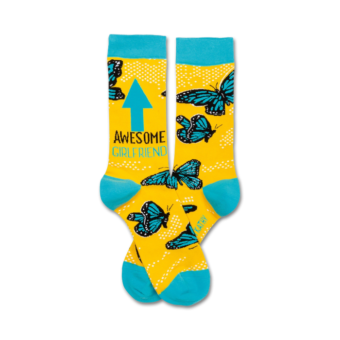 Pair of yellow crew socks with teal blue butterflies, an upward pointing arrow, and the text 'Awesome Girlfriend'. }}