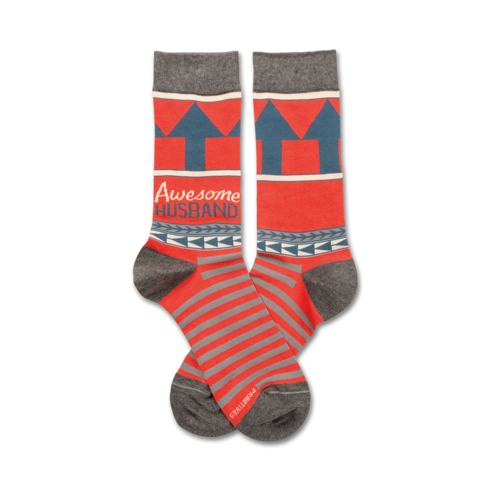 Pair of crew socks in coral and gray. They feature gray upward arrows, a navy band with the words