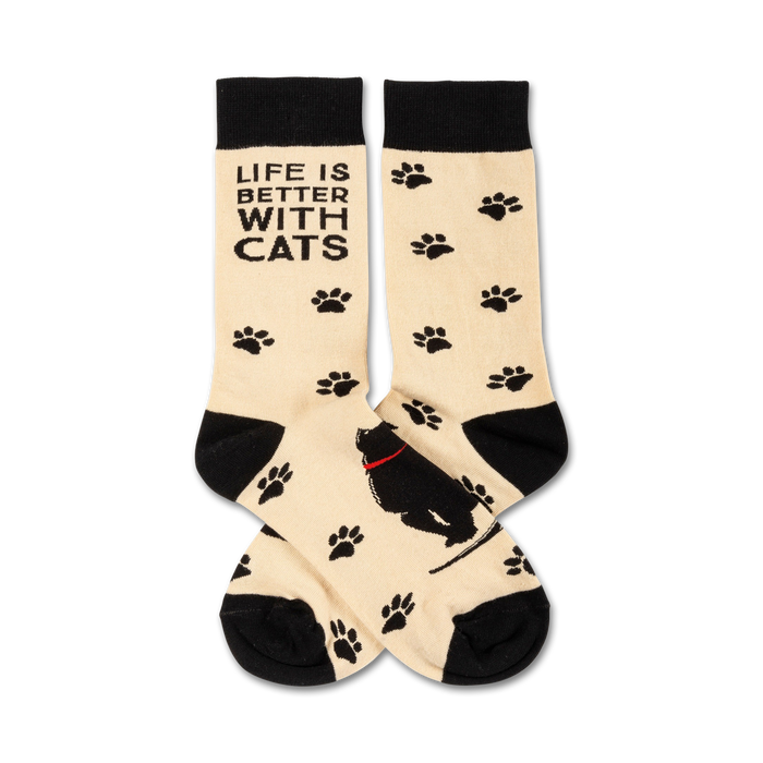 Cream crew socks with black paw prints and a black cat design.  Text reads, 'Life is better with cats'. }}