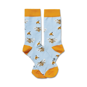 Pair of light blue crew socks with a pattern of yellow bees and small yellow flowers.  The socks have a mustard yellow cuff.