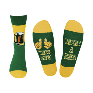 Crew socks in green and gold. One sock shows a beer mug, the other says 'This Guy Needs A Beer'.