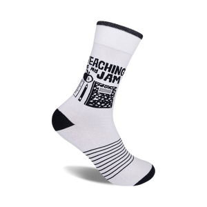 White crew socks with black stripes at the bottom and a design featuring black school supplies and the text 'Teaching Is My Jam'.