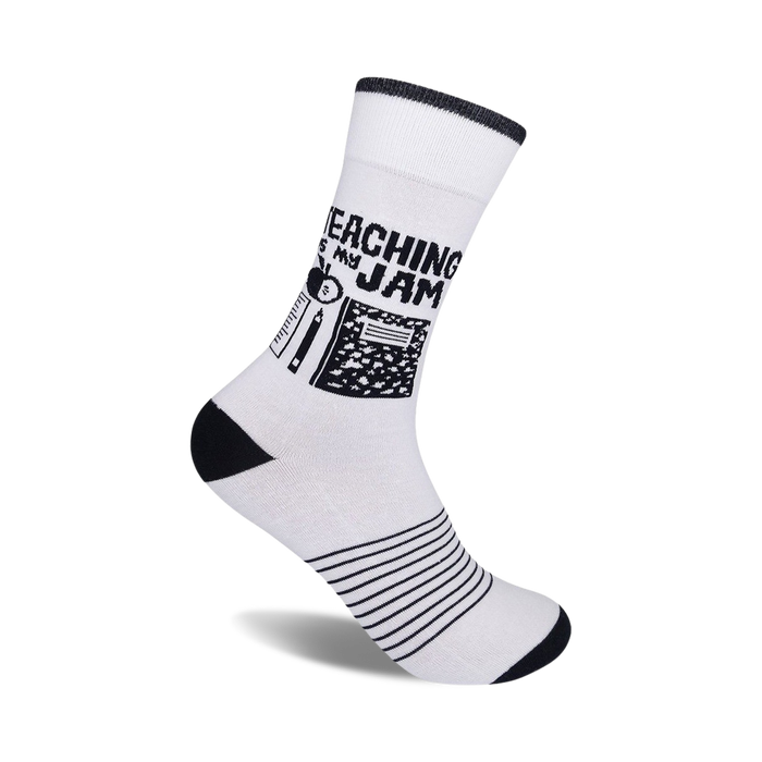 White crew socks with black stripes at the bottom and a design featuring black school supplies and the text 'Teaching Is My Jam'.