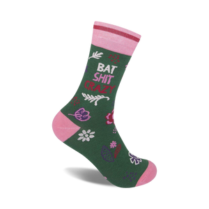 Green crew socks with pink accents. Features a playful 'Bat Shit Crazy' phrase and a whimsical floral pattern.