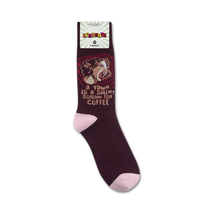 Lifestyle product shot showing maroon 'A Yawn Is A Silent Scream For Coffee' socks on a person's feet.