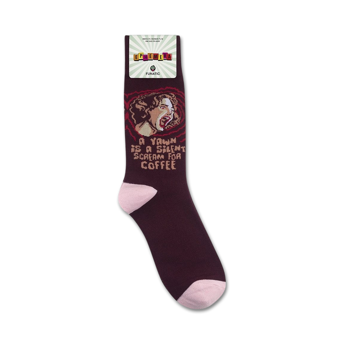 Lifestyle product shot showing maroon 'A Yawn Is A Silent Scream For Coffee' socks on a person's feet.