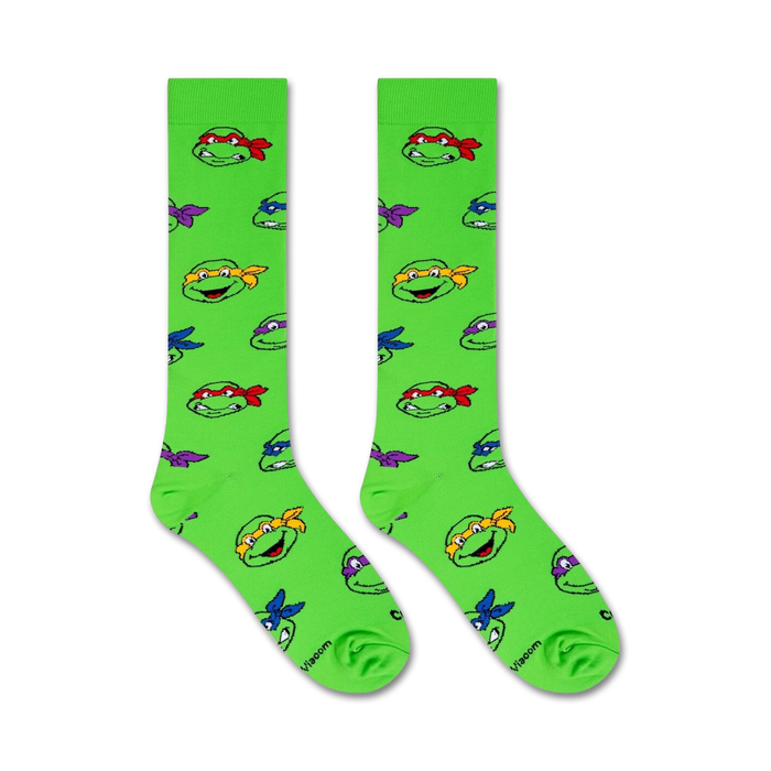 Flat lay image showing two TMNT knee-high socks on a white background.