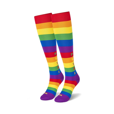 Pair of rainbow striped knee-high socks. Features the word 'PRIDE' vertically in the center. Red, orange, yellow, green, blue, and purple stripes.