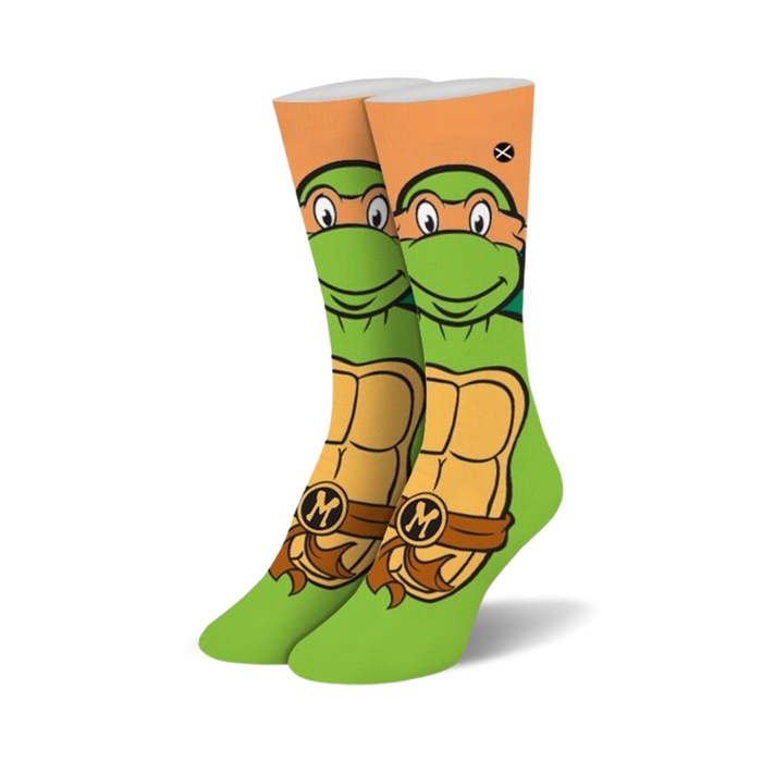 Crew socks in green and orange, featuring Michelangelo's face and shell from Teenage Mutant Ninja Turtles.  The 'M' is visible on his belt.