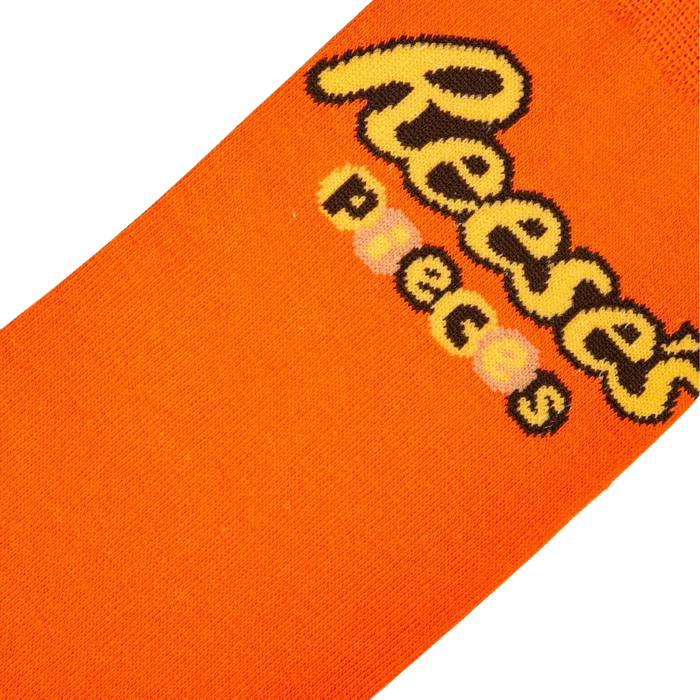 An orange sock with a brown and yellow pattern of the word 