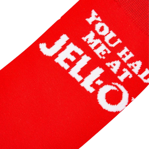 Close-up detail shot highlighting the 'You Had Me At Jell-O' text on the red sock.