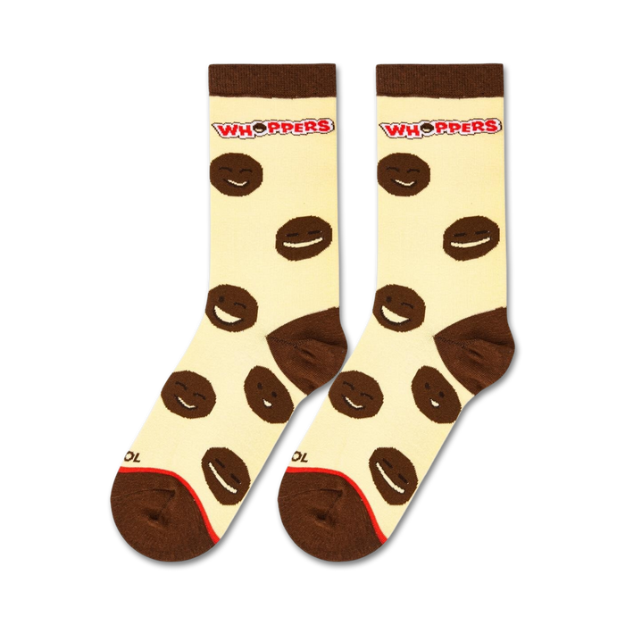 A close up of a pair of yellow socks with a brown smiling face on each sock. The face on the left is winking. The socks have a red and white striped cuff with the word 