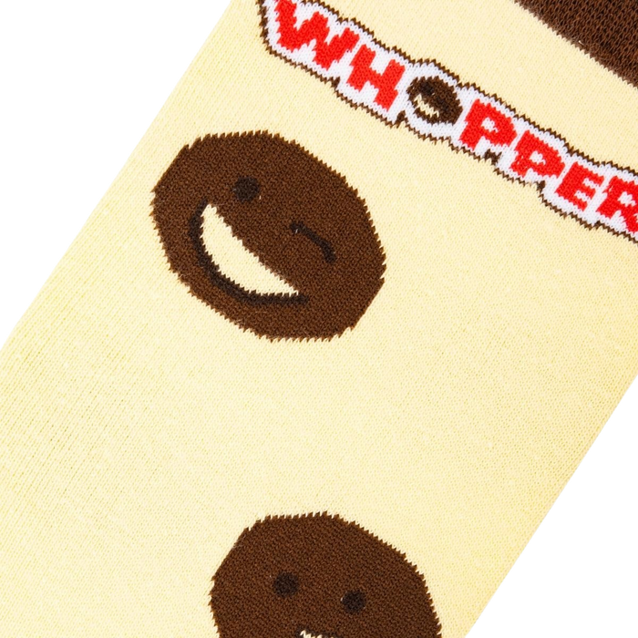 A close up of a pair of yellow socks with a brown smiling face on each sock. The face on the left is winking. The socks have a red and white striped cuff with the word 