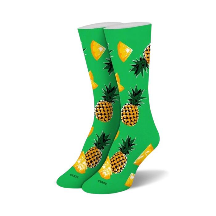Pair of crew socks, lime green with yellow and orange pineapples and pineapple slices.
