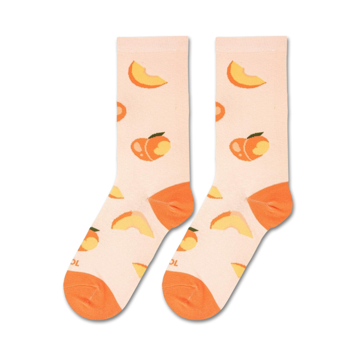 A pair of light peach crew socks laid flat, featuring a scattered pattern of whole peaches and peach slices.