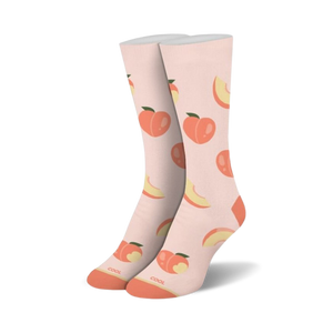 A pair of crew socks standing upright, light peach with an all-over pattern of whole peaches and peach slices, orange toes and heels.