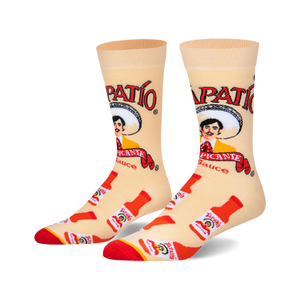 Pair of crew socks, beige background with red and white Tapatio hot sauce bottles and logo, featuring the Tapatio man.