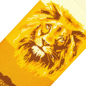 A close up of a knitted image of a lion's face in brown and yellow on a black background.