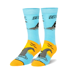 Pair of crew socks, light blue and orange, featuring a graphic of a man riding a Loch Ness Monster and the word 'BELIEVE'.