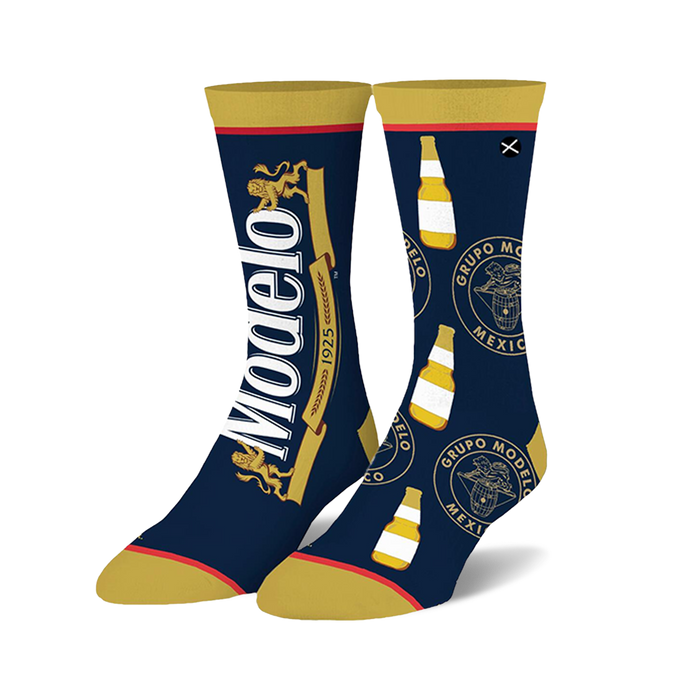 Pair of Modelo Split crew socks in navy blue and gold. Features Modelo logo and bottle graphic repeats.