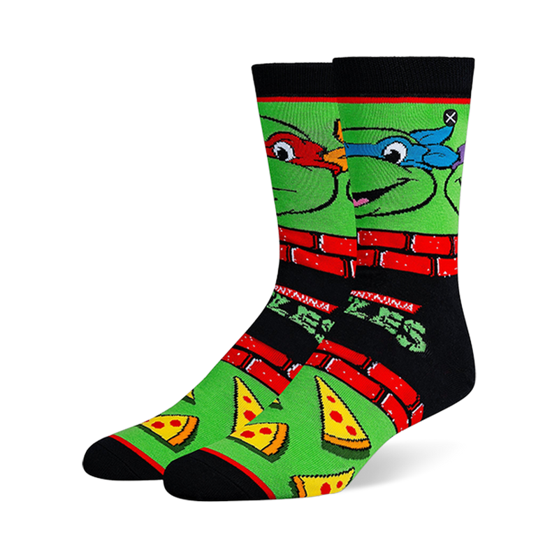 Black and green crew socks with Teenage Mutant Ninja Turtle faces, red brick borders, classic logos, and pizza slices.
