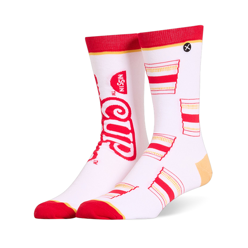 White crew socks featuring a mismatched design with a large red Cup Noodles logo on one and a pattern of cups on the other.