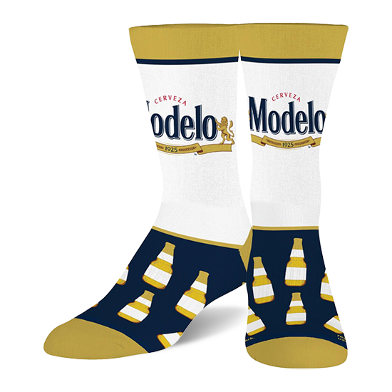 Two crew socks with white calves featuring the Modelo beer logo, navy blue feet with yellow-capped beer bottles, and gold toes, heels, and cuffs. }}