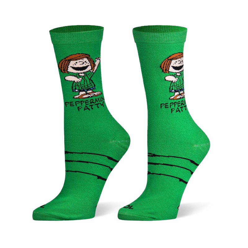 Bright green crew socks showing Peanuts character Peppermint Patty, her printed name, and black sketchy lines on the foot.