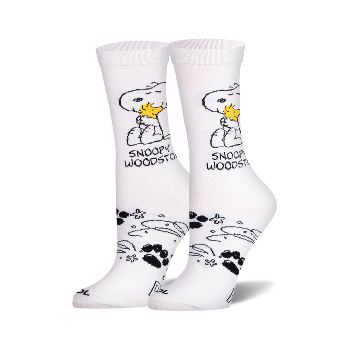 Pair of white crew socks. Snoopy and Woodstock are featured in black and yellow, along with paw prints and stars. }}