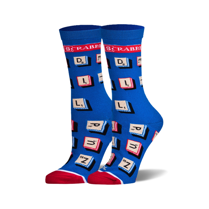 A pair of women's crew socks in blue with red and white accents. The socks are covered in Scrabble letter tiles. }}