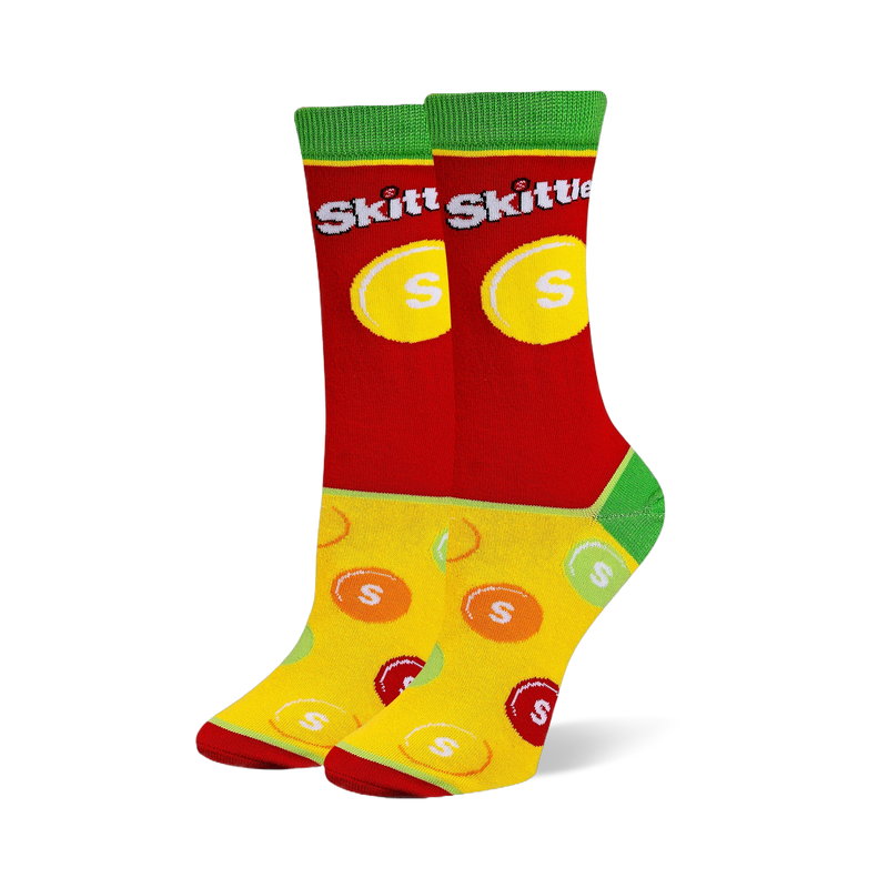 Crew socks with a red upper featuring the Skittles logo, green cuffs and heels, and a yellow foot with scattered candy pieces.