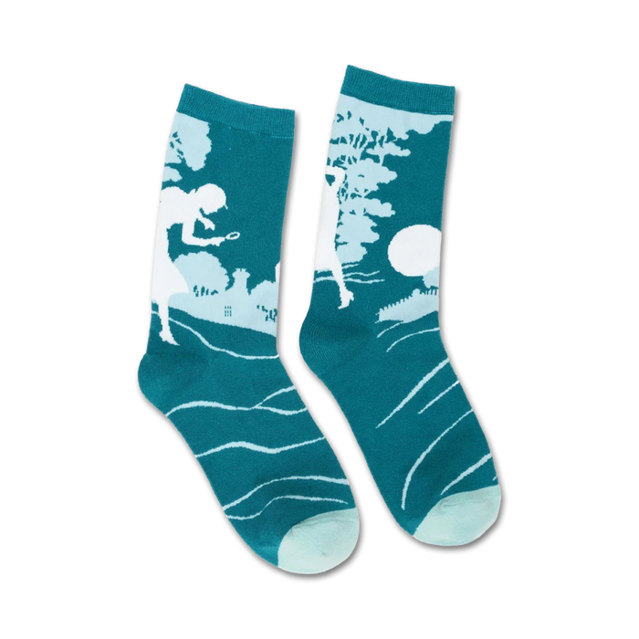 A pair of teal crew socks with a white silhouette of Nancy Drew solving a mystery. Subtle wave pattern at the bottom. }}