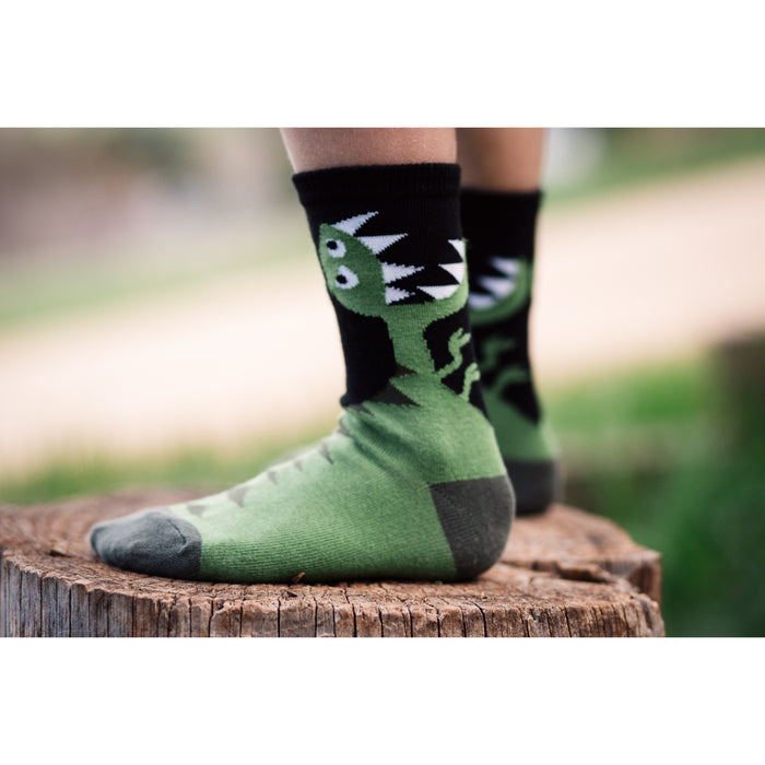 A pair of green dinosaur socks with black toes and heels.