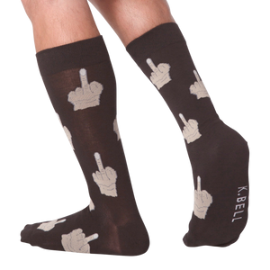 Lifestyle shot: Person's legs wearing dark brown crew socks with beige middle finger design.  K.BELL logo is visible.