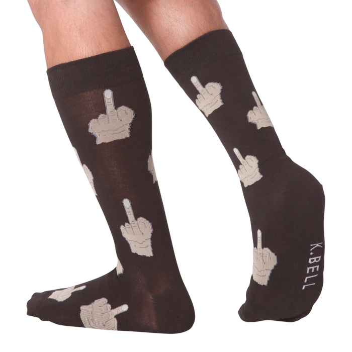 Lifestyle shot: Person's legs wearing dark brown crew socks with beige middle finger design.  K.BELL logo is visible.