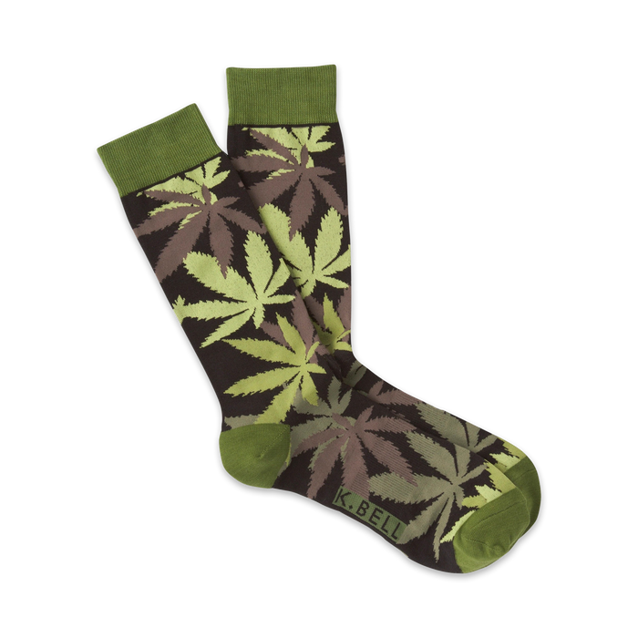 A pair of crew socks with a marijuana leaf pattern. The leaves are in shades of light and dark green and brown on a dark brown background. The socks have olive green cuffs. }}