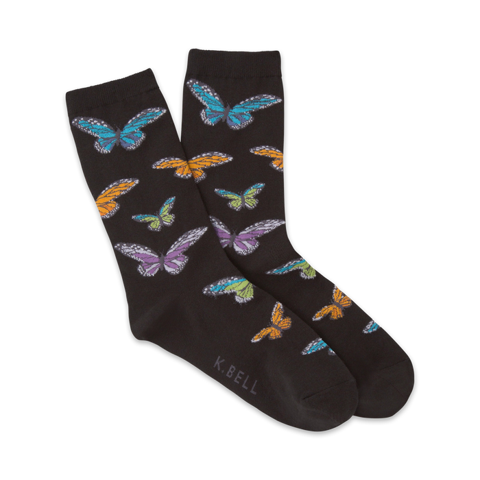 Pair of black crew socks adorned with colorful butterflies in teal, purple, orange, and yellow. The socks are playfully arranged, showcasing the design. }}