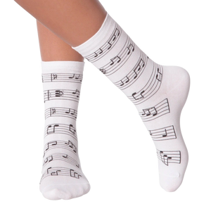 Close up of a person's legs wearing white musical note socks.