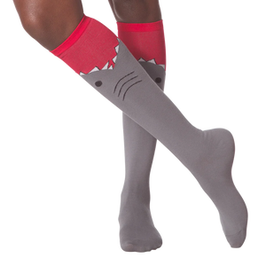 Lifestyle shot showing a person wearing the gray and red shark knee-high socks.