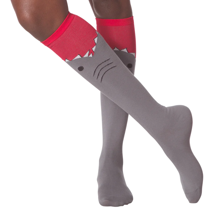 Lifestyle shot showing a person wearing the gray and red shark knee-high socks.