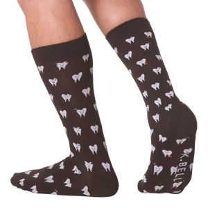 Lifestyle shot showing the socks on a person's feet.  The socks are dark brown with a tooth pattern. The image is on a black background.