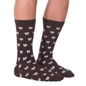 Another lifestyle shot showing the socks on a person's feet, this time from the front.  The socks are dark brown with a tooth pattern. The image is on a black background.