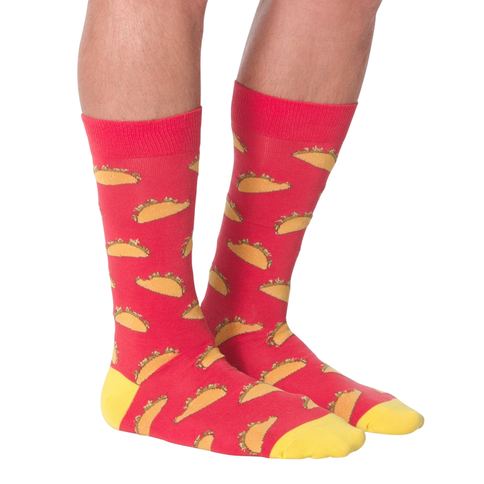 A pair of red socks with a pattern of tacos on them. The socks are pulled up to the wearer's mid-calf.