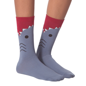 A pair of gray socks with a shark design. The shark has a red fin and black eyes.